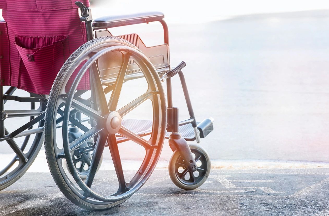 A close up of an empty wheelchair on the sidewalk